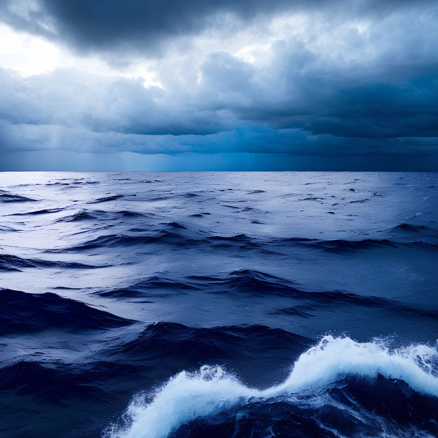 Stormy sky over dark ocean waves with white foam and dramatic cloudscape