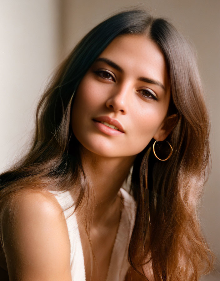 Woman with ombre hair and teal highlights in beige top gazes at camera