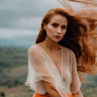 Woman with long flowing hair in sheer white top against dusky sky