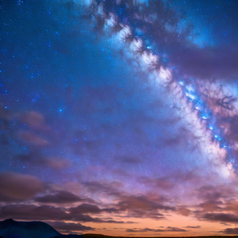 Starry night sky over silhouetted mountains at sunset