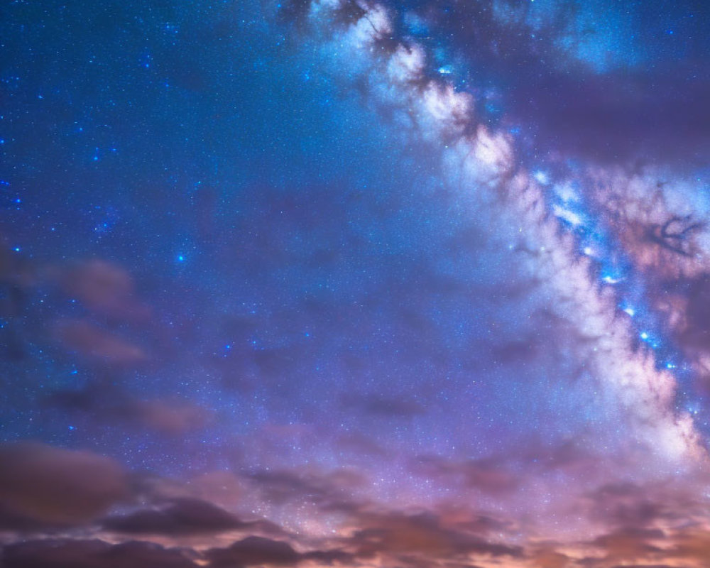 Starry night sky over silhouetted mountains at sunset