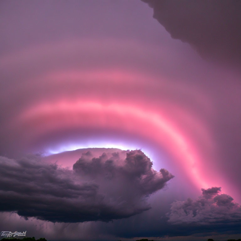 Dramatic sky with pink-tinged eye-shaped cloud in storm