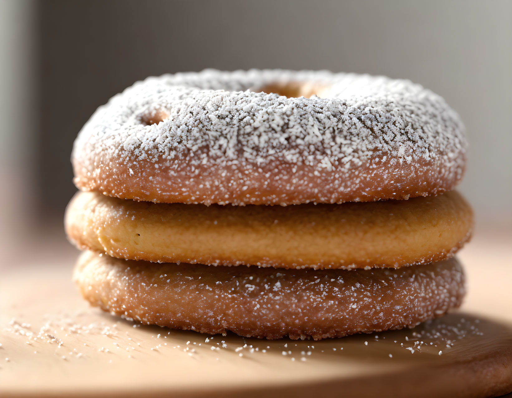 Three Powdered Sugar Donuts on Wooden Board with Soft-focus Background