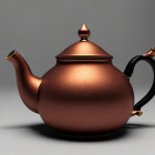 Bronze teapot with curved spout, black handle on grey background