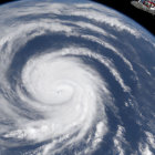 Spacecraft orbits massive swirling hurricane near Earth's limb.