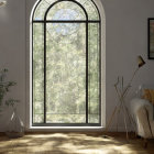 Tranquil living room with arched window, white sofa, plant, and soft lighting