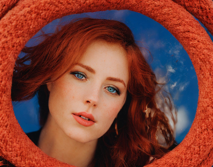 Red-Haired Woman with Blue Eyes Framed Against Blue Sky