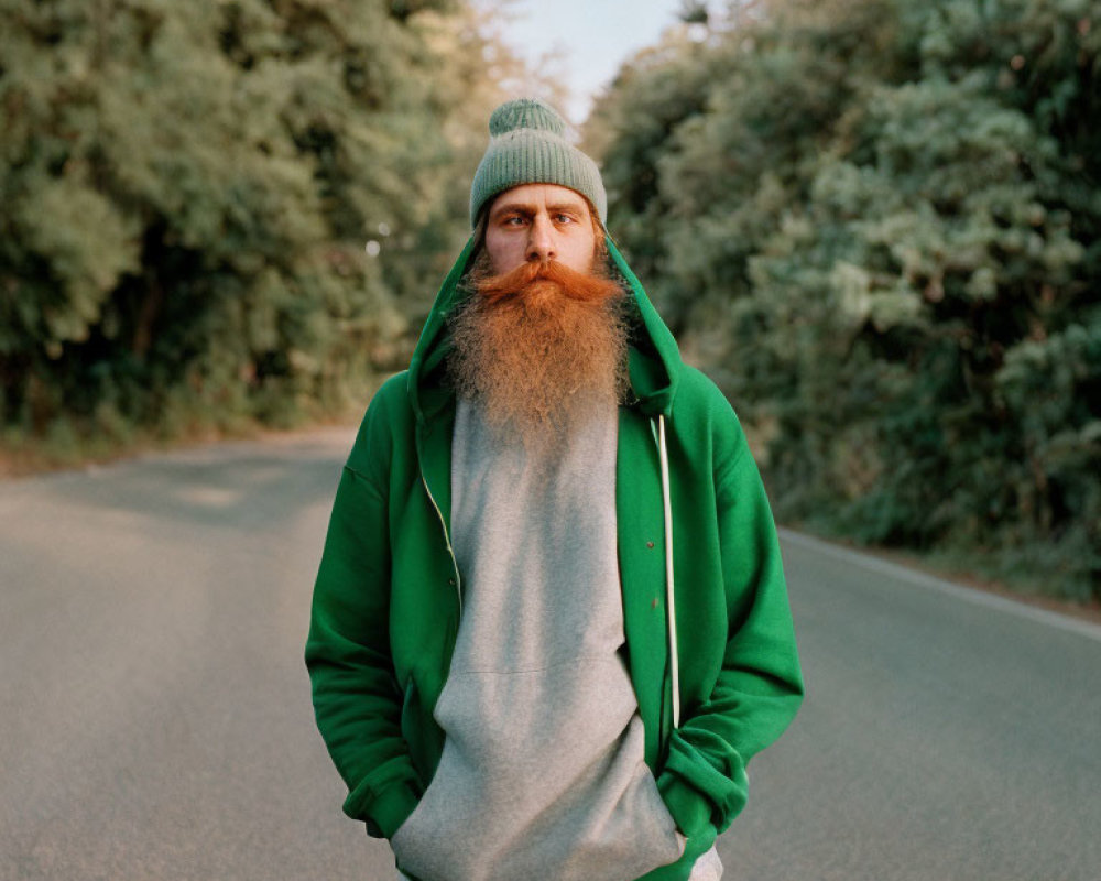 Bearded Person in Green Beanie and Hoodie on Road with Trees