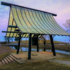 Japanese garden with tiled roof gazebo and cherry blossoms at dusk