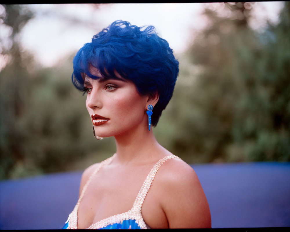 Blue-haired woman in contemplation against nature backdrop