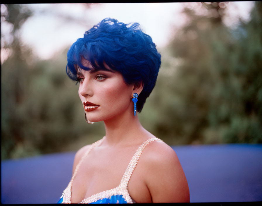 Blue-haired woman in contemplation against nature backdrop