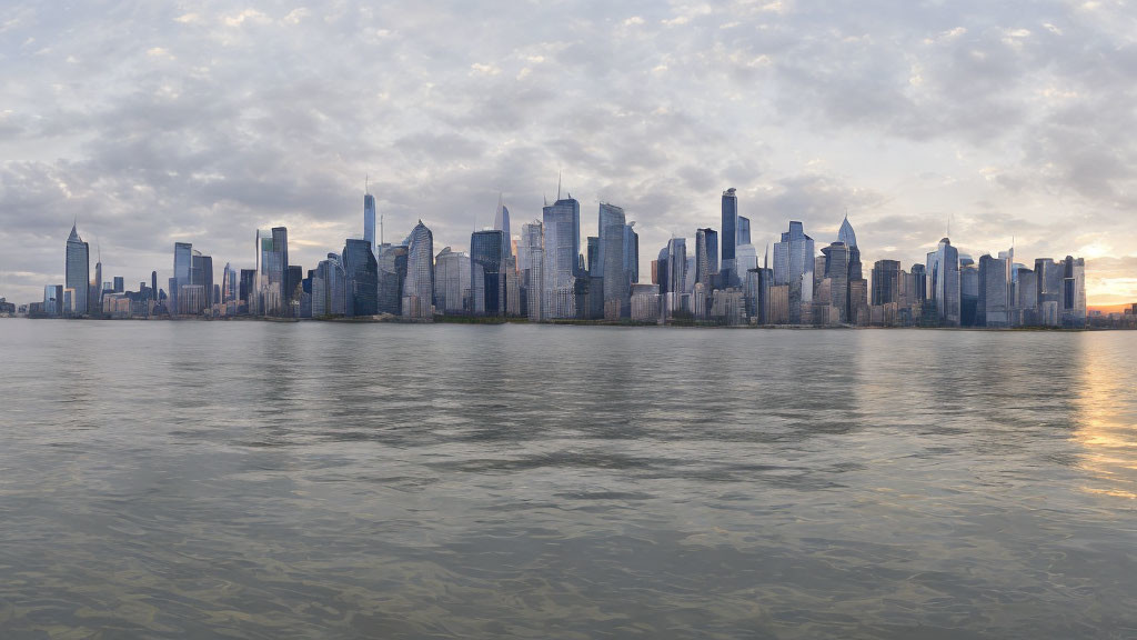 City skyline panorama over calm water at dusk with cloudy sky reflections