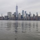 City skyline panorama over calm water at dusk with cloudy sky reflections