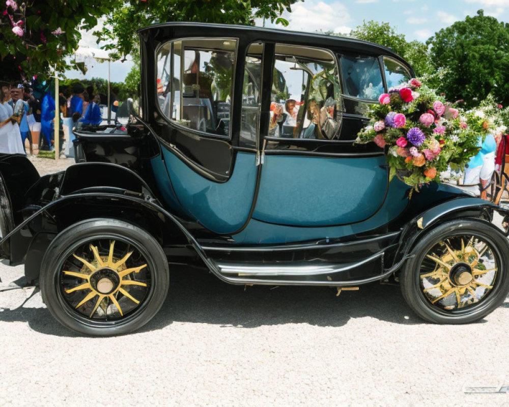 Vintage black and teal car with flowers displayed at outdoor event