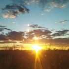 Scenic sunrise over rugged mountain landscape with scattered clouds