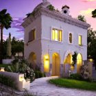 White Two-Story House at Twilight with Lit Interior and Garden Path