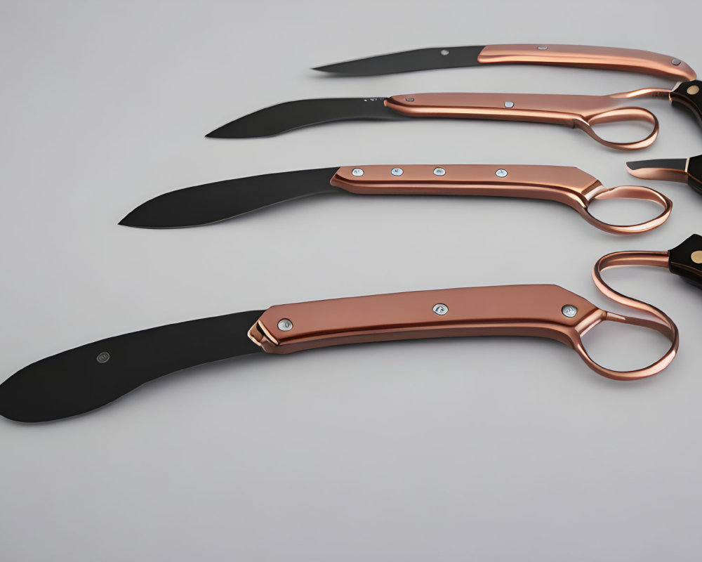 Black-bladed knives with copper accents on light background