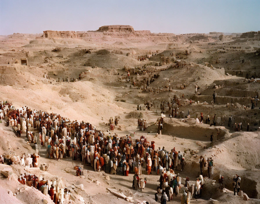 Crowd at Arid Excavation Site with Ancient Structures in Desert