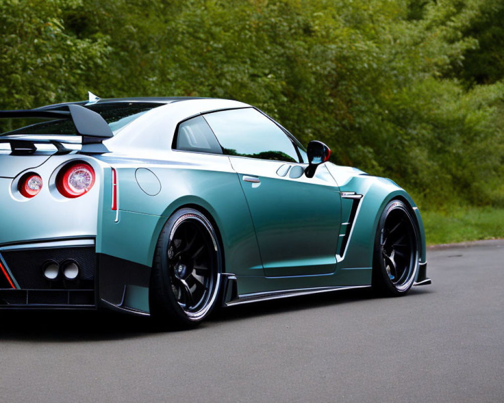 Turquoise Sports Car with Black Spoiler and Wheels on Asphalt Road