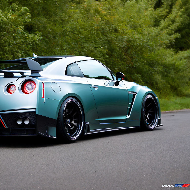 Turquoise Sports Car with Black Spoiler and Wheels on Asphalt Road