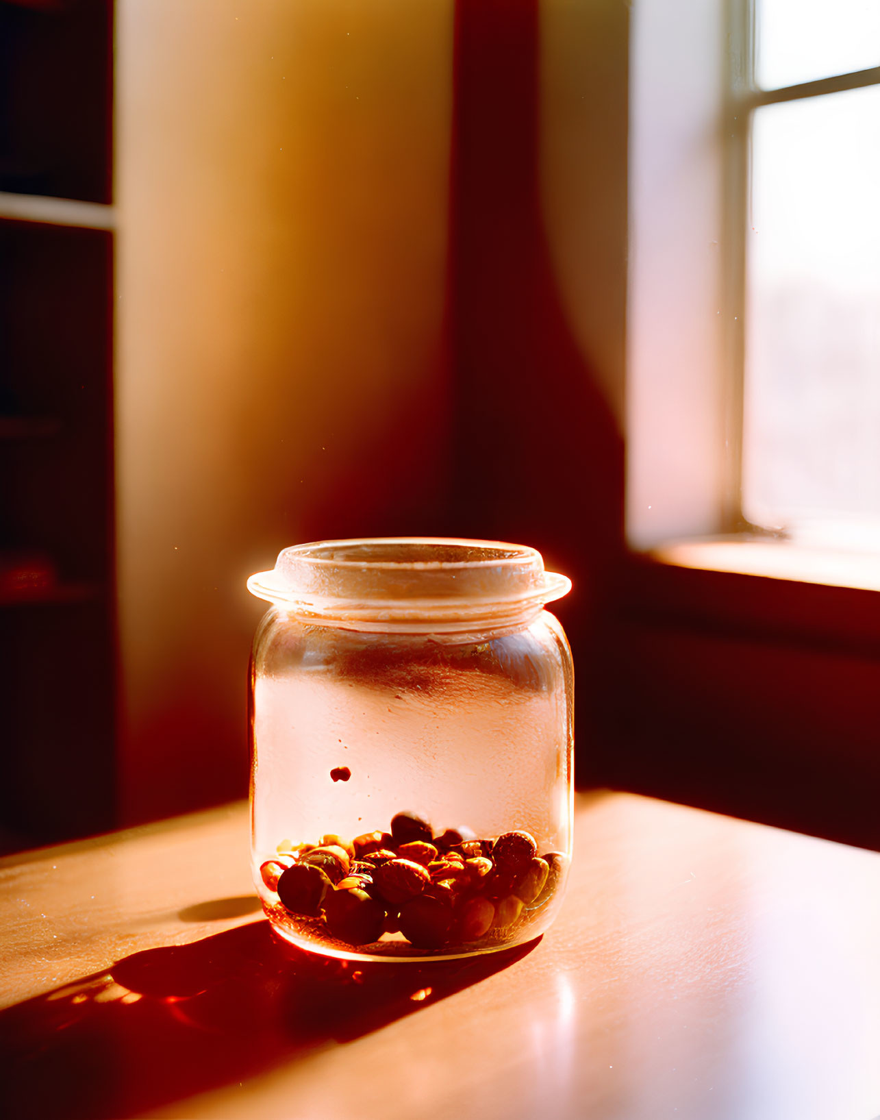 Glass jar with berries on wooden surface in warm sunlight