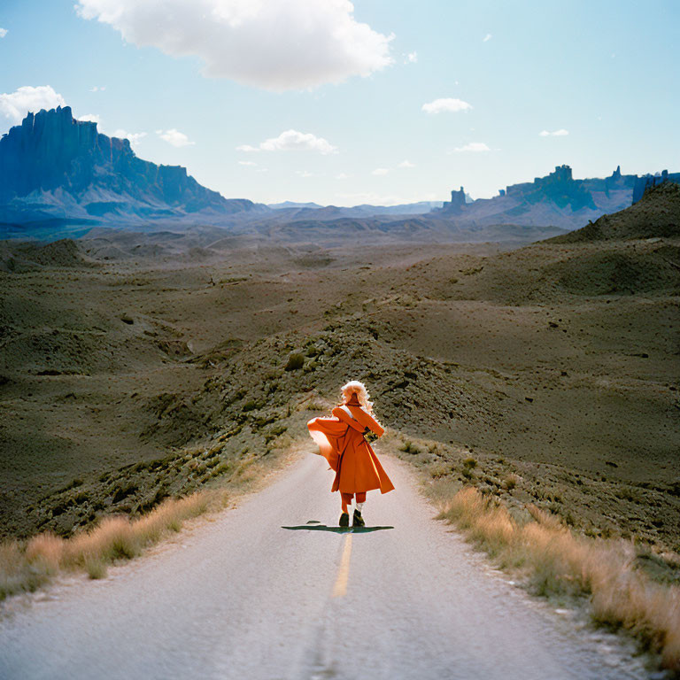 Vibrant orange coat violinist in rugged landscape under blue sky