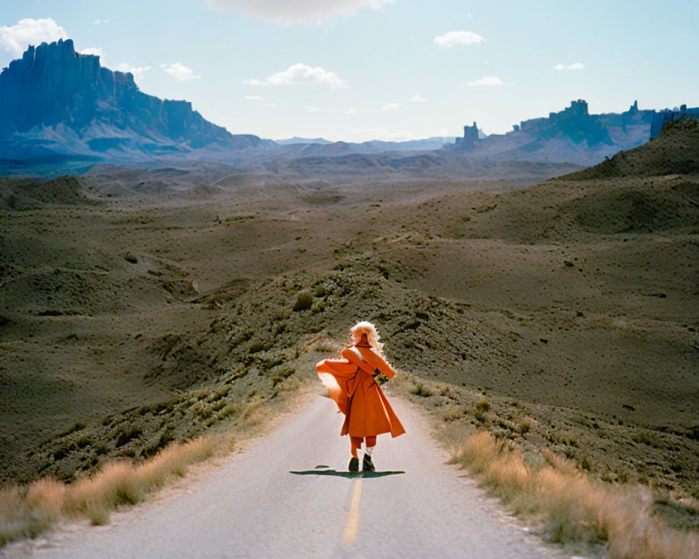 Vibrant orange coat violinist in rugged landscape under blue sky