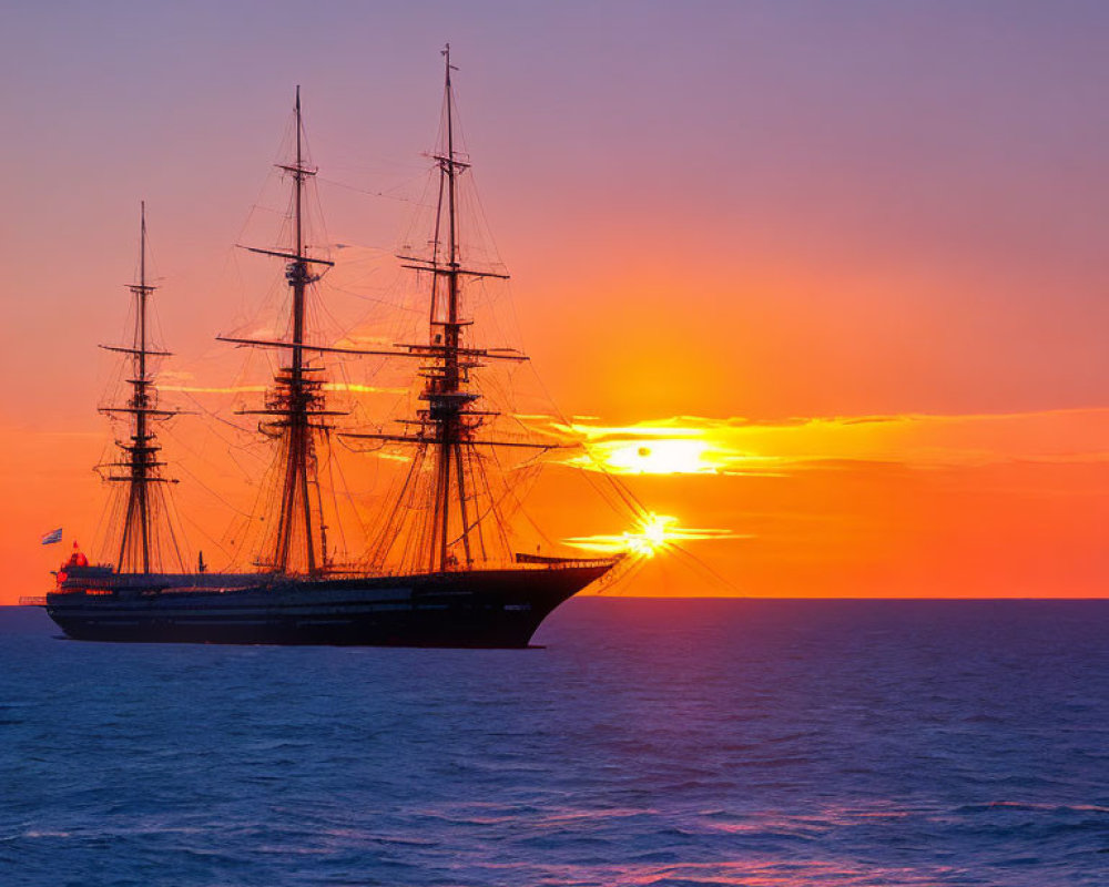 Sailboat silhouette against vibrant sunset horizon