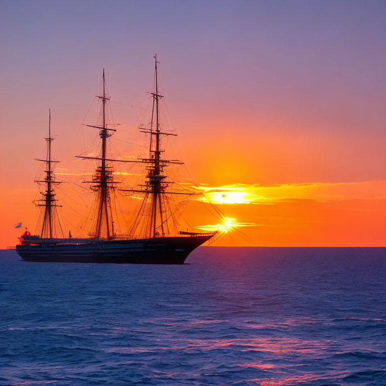 Sailboat silhouette against vibrant sunset horizon