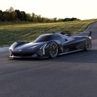 Sleek black futuristic race car on track with large wheels