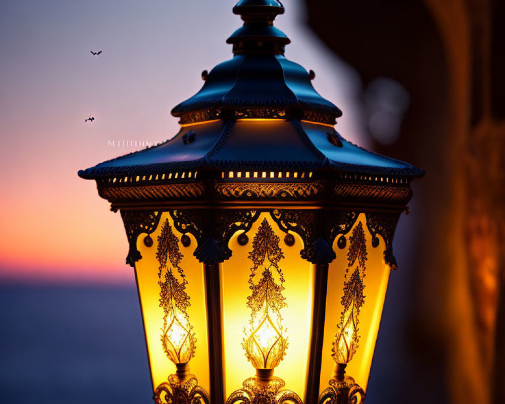 Ornate lantern glowing in twilight with birds in the distance