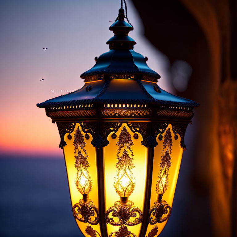 Ornate lantern glowing in twilight with birds in the distance