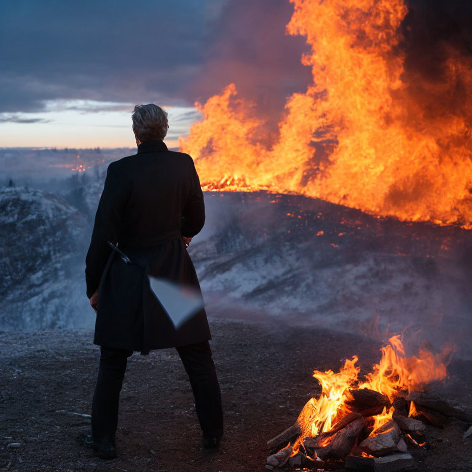 Person in Black Coat with Briefcase Facing Large Fire at Dusk