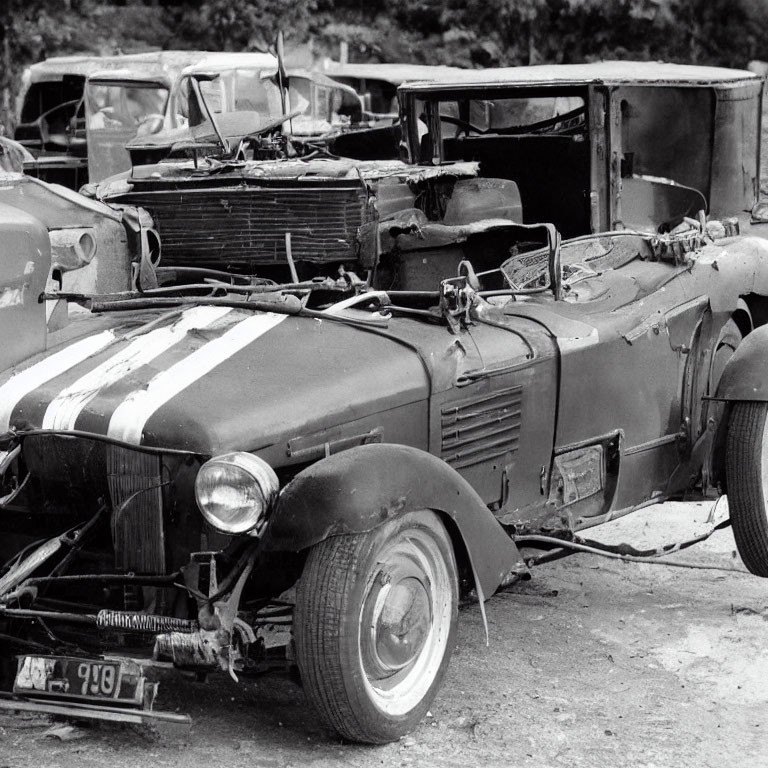 Abandoned damaged car with hood stripes among derelict vehicles