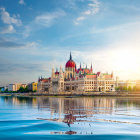 Person rowing towards castle on island under serene sky