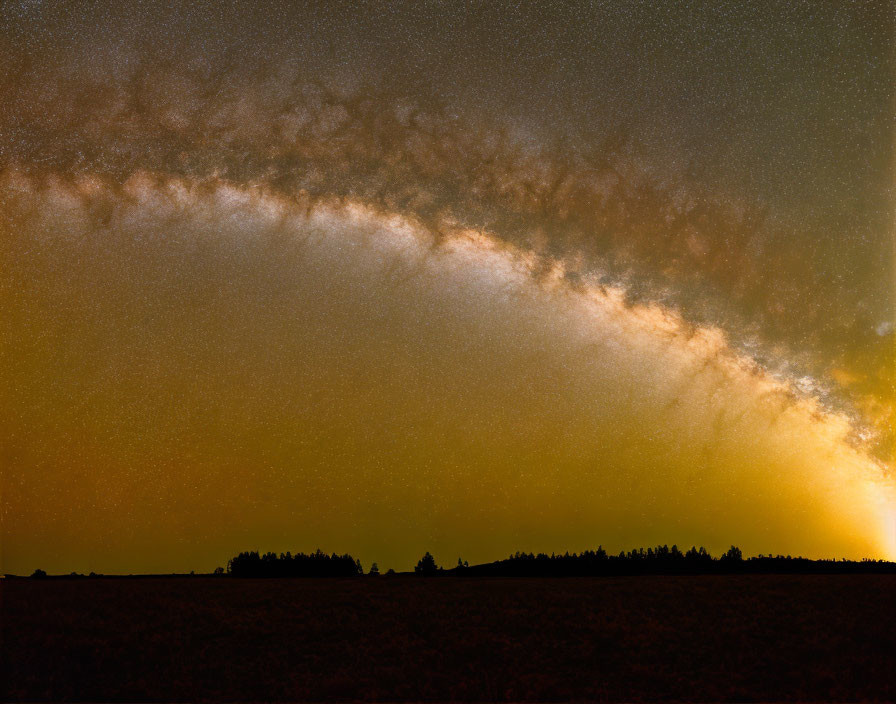 Stunning Milky Way arc over dark landscape at twilight