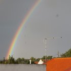 Vibrant rainbow over cobblestoned European street at sunset