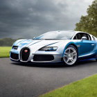 Blue and Silver Bugatti Veyron Supercar on Asphalt Road with Stormy Sky