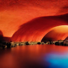 Vivid red-lit cave over serene blue waters with rough textured walls