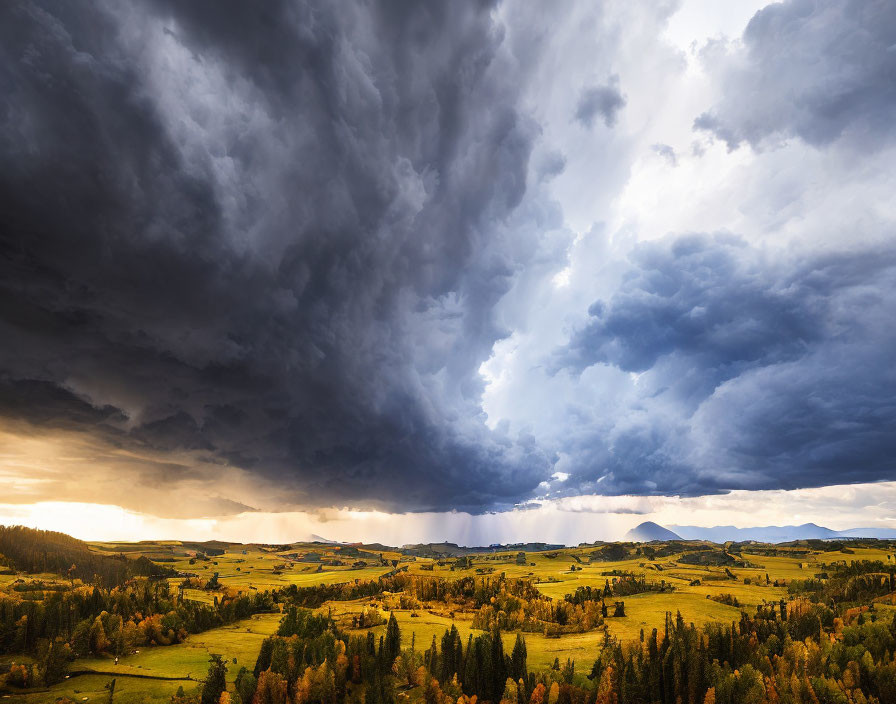 Golden landscape under dramatic storm clouds with sunlight piercing through