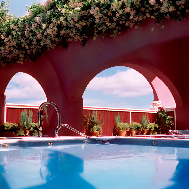 Arch-framed Pool Area with Hanging Flowers and Blue Sky