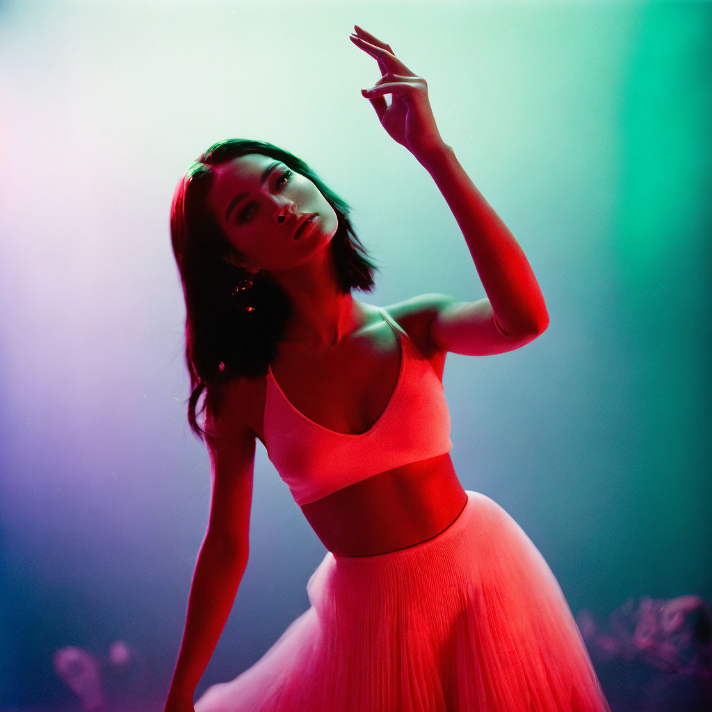 Woman in Pink Outfit Poses Gracefully Under Red and Green Lighting