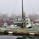 Serene harbor scene with boats, pier, buildings, and misty atmosphere