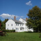 Country house surrounded by blooming trees and vibrant garden at dusk