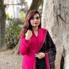 Woman in Pink Coat and Lace Scarf Standing in Misty Forest