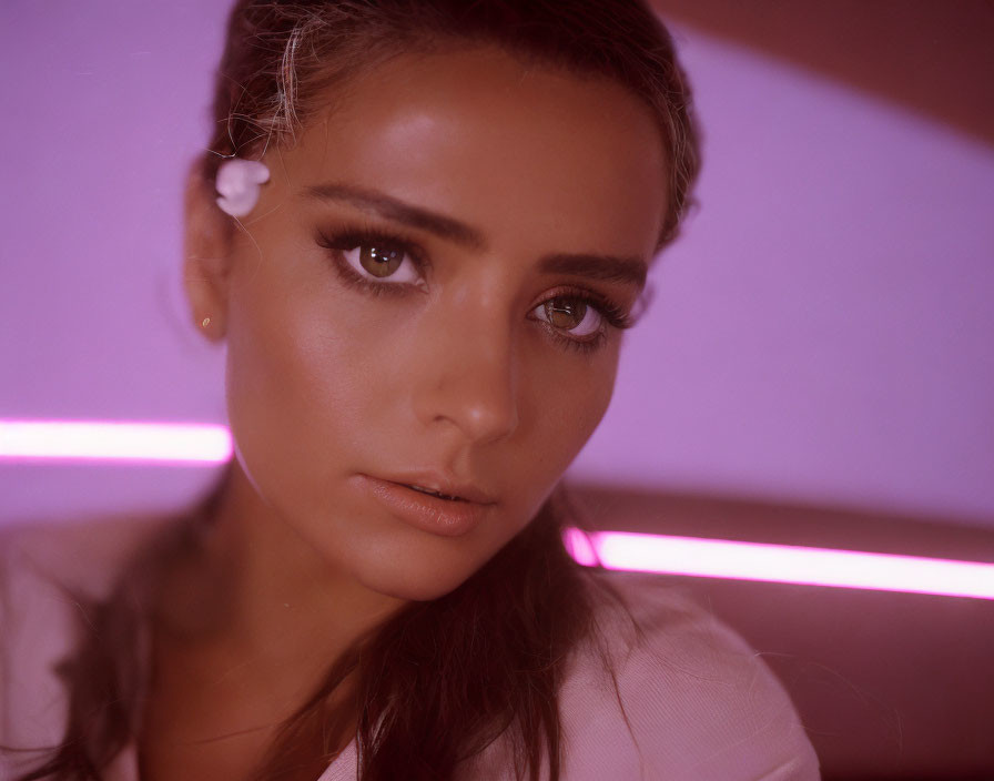 Portrait of Woman with Striking Eyes in Soft Pink Lighting