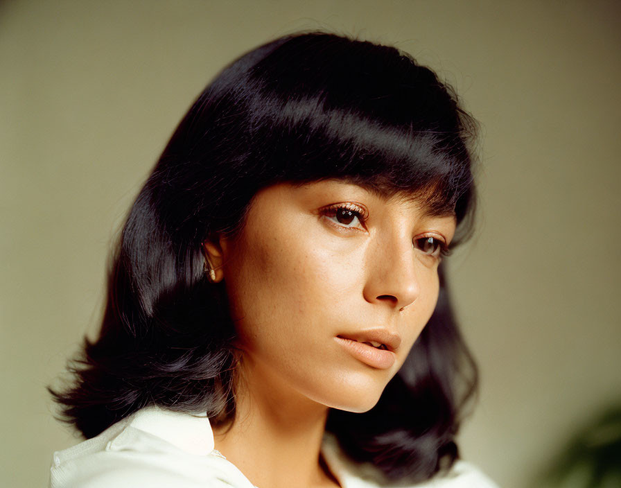 Portrait of woman with dark bob haircut and white shirt