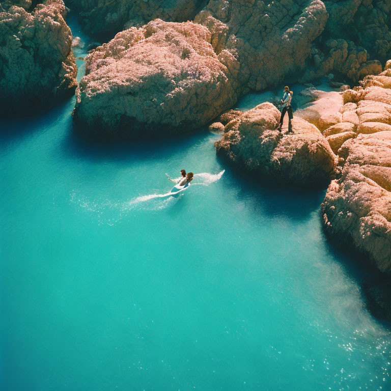 Swimming in Turquoise Water Near Pink Rocks with Watcher