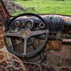 Steampunk-themed cockpit with brass gears, dials, levers, and steering wheel against mountain