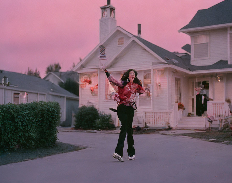 Woman jogging past suburban houses with headphones at dusk